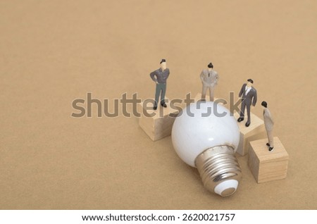 Exploring Ideas: Miniature Team Analyzing Light Bulb for Creative Solutions