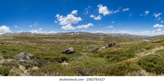 Exploring the Main Range Walk at Mount Kosciuszko with stunning views of the alpine landscape with green hills and stony rocks, Australia