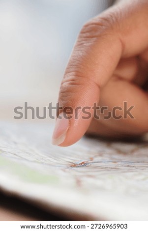 Exploring a map with a finger at a table
