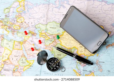 Exploring travel essentials with a map, compass, smartphone, and pen for planning journeys in various countries