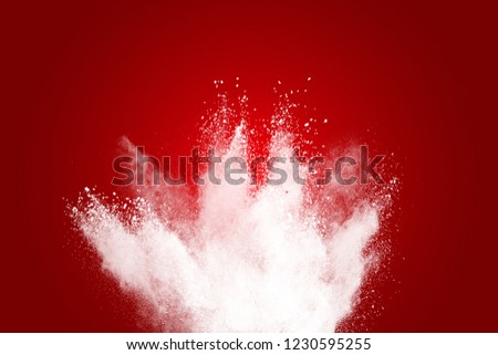 Explosion of a cloud of powder of particles of white color on a red bottom