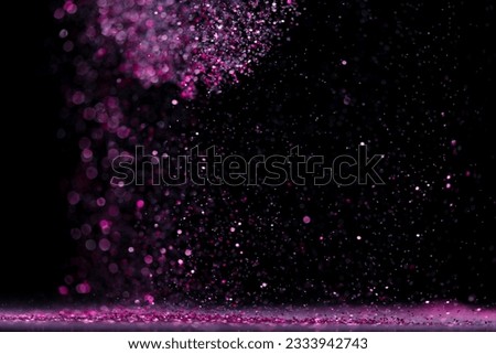 Explosion metallic pink glitter sparkle. Choky Glitter powder spark blink celebrate, blur foil explode in air, fly throw pink glitters particle. Black background isolated, selective focus Blur bokeh
