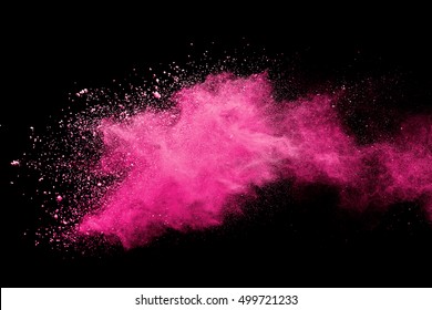 Explosion of pink colored powder on black background