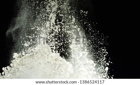 Explosion of white flour on black background. Stock footage. Explosion of thick cloud of white powder with crumbling particles on black isolated background