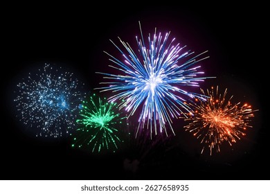 An explosive array of fireworks in vibrant blue, green, red, and purple colours lights up the night sky in a dazzling celebration. Perfect for holiday events, New Year celebrations, and festival.