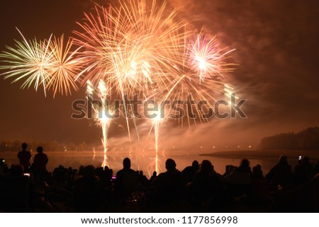Explosive and colorful fireworks at the Annual Global Fest Pyromusical competition in Elliston Park, Calgary, Alberta. Summer festival celebrating multiculturalism. Silhouette of people watching.