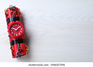 Explosive dynamite time bomb on white wooden background, top view. Space for text