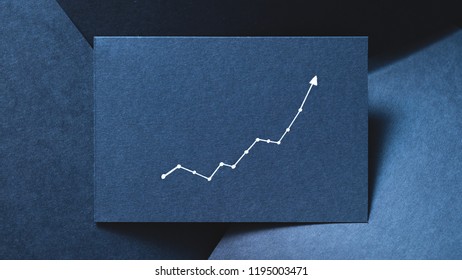 exponential graph on blue layered paper backdrop. growth increase progress concept.