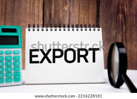 The EXPORT - text on notepad next to calculator and magnifying glass. Calculation of the financial value and profit or cost of EXPORT. Global export marketing.