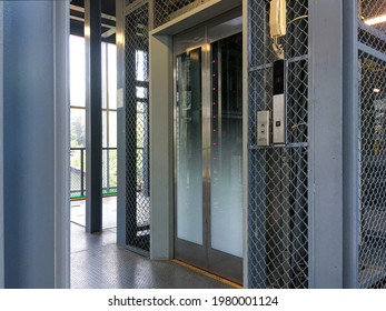 exposed elevator with gradient ceramic fritted glass door and metal net cover