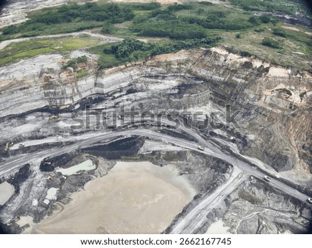 Exposed Mining Pit With Pale Sediment and Steep Earth Layers