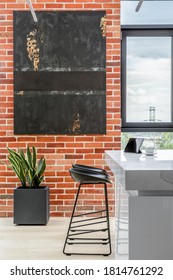 Exposed Red Brick On Kitchen Wall With Modern Art And White Kitchen Table With Black Chairs