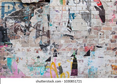 Exposed Weathered Brick Wall With Torn Street Posters 