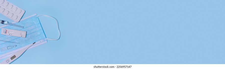 Express Covid-19 XBB.1.5 Kraken Variant strain test,Schnelltest, medical mask, syringe,thermometer,medicine on a blue background.Diagnosis of virus, Inhibition of disease outbreaks.Copy space. Banner - Shutterstock ID 2256957147