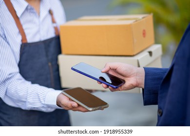 Express Delivery Service. Courier Delivering Package To Man And Scan For Pay,Delivery And Mailing Service Concept.