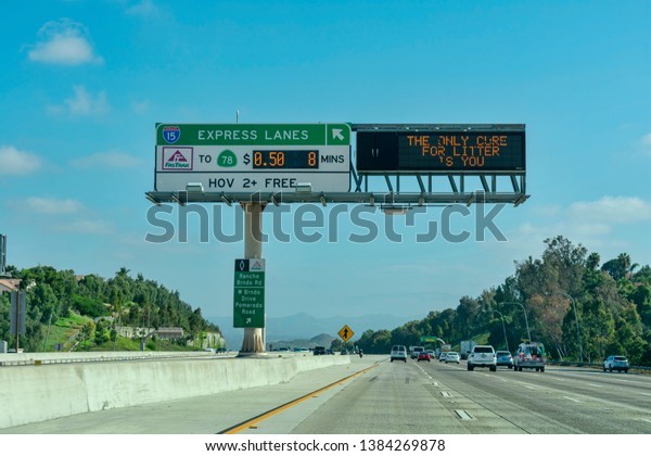 Express lanes marked by overhead signage, and\
smaller HOV sign located in the median on highway. The toll amount\
is posted on an electric changeable board - San Diego, California,\
USA - April 22, 2019