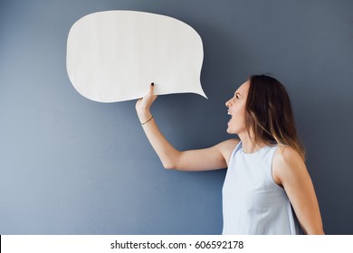 Express yourself!. Young woman shouting with a speech bubble against a gray background 