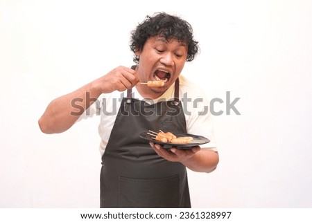 expression of asian man eating sausage Imagine de stoc © 