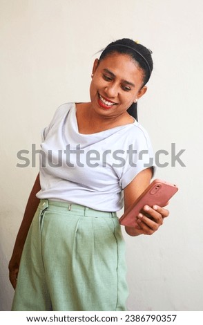 The expression of an Asian woman is happy and surprised when she receives a call and reads a short message