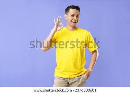 Expression of cheerful confident asian man have all under control, wink encouraging and show okay gesture, approve plan, congratulating person, saying well done, rate excellent job, standing purple b