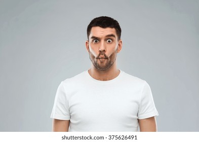 Expression, Fun And People Concept - Man With Funny Fish-face Over Gray Background