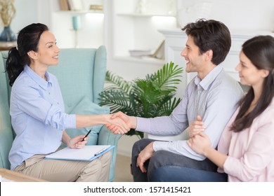 Expression Of Gratitude. Professional Psychologist And Happy Relieved Couple Handshaking In Office After Therapy, Free Space