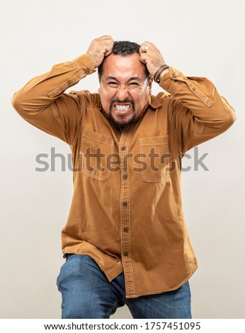 expression and people concept - angry man with funny face over gray background. Adult over 40 years of age.