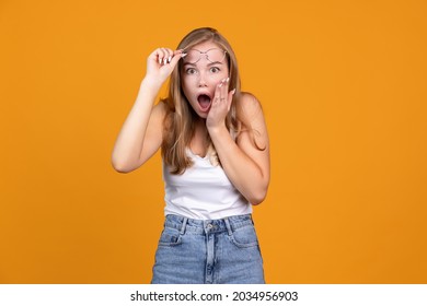 Expression Of Surprise. Emotional Condition Of Surprised Young Female Model Posing On Orange Studio Background. Concept Of Fasial Expressions, Emotions, Surprise And Feelings. Copy Space For Ad