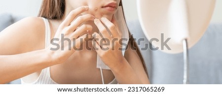 Expression worry asian young woman hand touching pustule around the chin and mouth, allergic when wear mask, makeup, show squeezing pimple spot from face. Beauty care, skin problem by acne treatment.