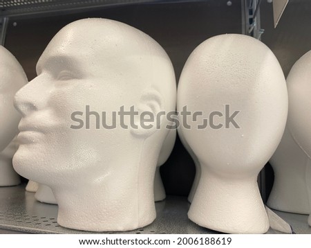 Expressionless Styrofoam male and female heads on a shelf