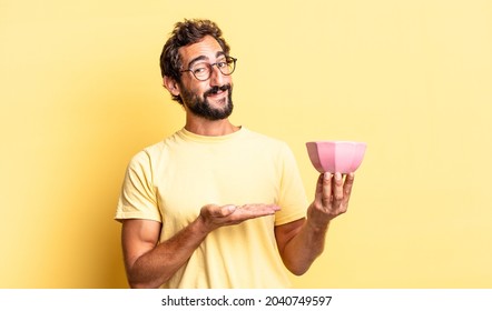 expressive crazy man smiling cheerfully, feeling happy and showing a concept and holding a pot