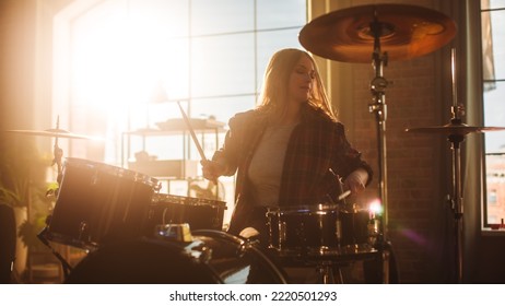 Expressive Drummer Girl Playing Drums in a Loft Music Rehearsal Studio Filled with Light. Rock Band Music Artist Learning Drum Solo. Portrait of Woman Enjoying Creating Rythm. - Powered by Shutterstock