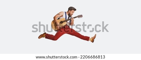 Expressive musician wearing retro style clothes playing guitar like rockstar isolated on white background. Vintage fashion, music, art, emotions, music festiva concept. Copy space for ad