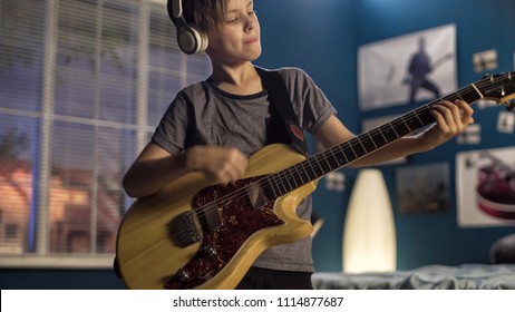 Expressive Teen Boy Learning Guitar Play While Standing In Bedroom And Playing With Passion