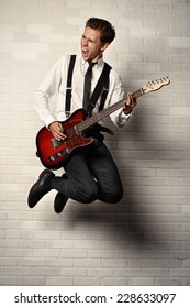 Expressive young man playing rock-n-roll music on his electric guitar. Retro, vintage style. 