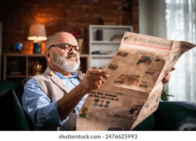 Expresssive Indian asian senior old man reading newspaper at home - Powered by Shutterstock - Get 15% off with code: PIKWIZARD15