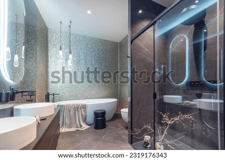 Exquisite bathroom design. Modern shower cabin, stylish accessories. Oval mirrors with 
illumination.