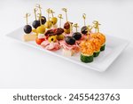 Exquisite gourmet finger food appetizer platter with an elegant assortment of cheese. Shrimp. Olives. Salami. Cucumber. Grape. And sundried tomato. Perfect for catering. Parties. And banquets