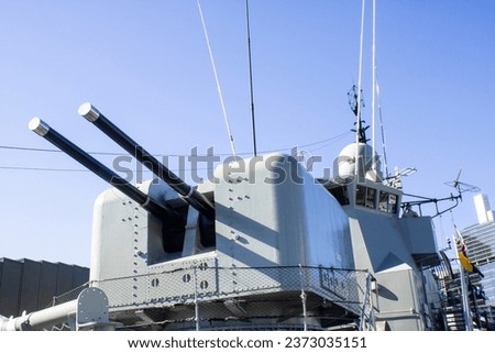 An exquisite image showcasing the elegance and power of an Australian naval warship, featuring a striking white cannon with two imposing black barrels. 