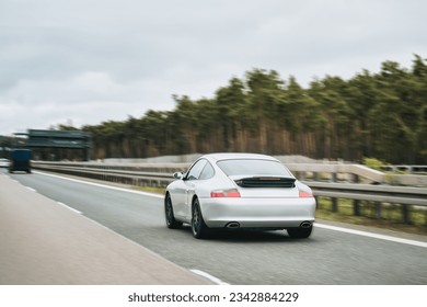 Exquisite Speed and Style on the Highway. Modern European Sportcar. Silver German roadster vehicle on the highway. Silver sport coupe. The expensive sports car on public roads. Autobahn speeding - Shutterstock ID 2342884229