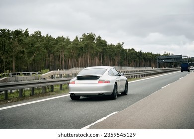 Exquisite Speed and Style on the Highway. Modern European Sportcar. Silver German roadster vehicle on the highway. Silver sport coupe. The expensive sports car on public roads. Autobahn speeding - Shutterstock ID 2359545129