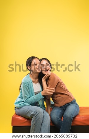 exspression of happiness two asian young woman sitting together