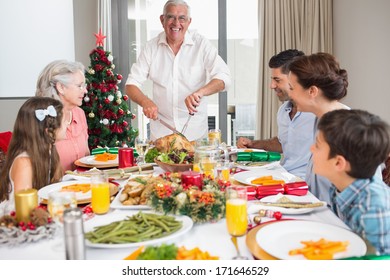 Extended Family At Dining Table For Christmas Dinner In The House