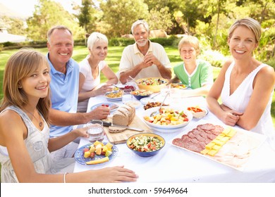 Extended Family Enjoying Meal In Garden