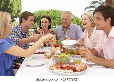 Extended Family Group Enjoying Outdoor Meal Together