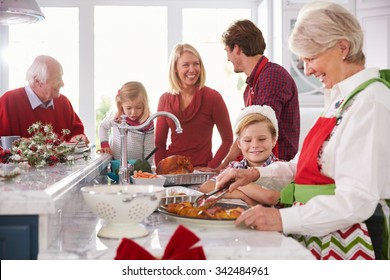 Extended Family Group Preparing Christmas Meal In Kitchen