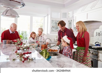 Extended Family Group Preparing Christmas Meal In Kitchen