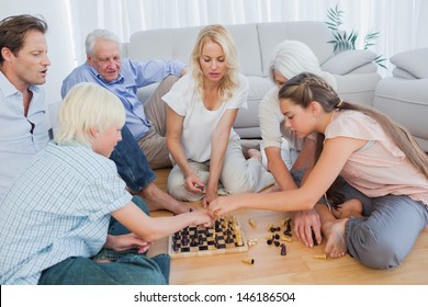 Extended Family Playing Chess In The Living Room