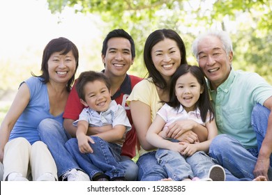 Extended Family Sitting Outdoors Smiling