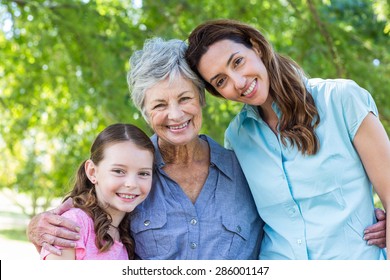 Extended family smiling in the park on a sunny day - Powered by Shutterstock